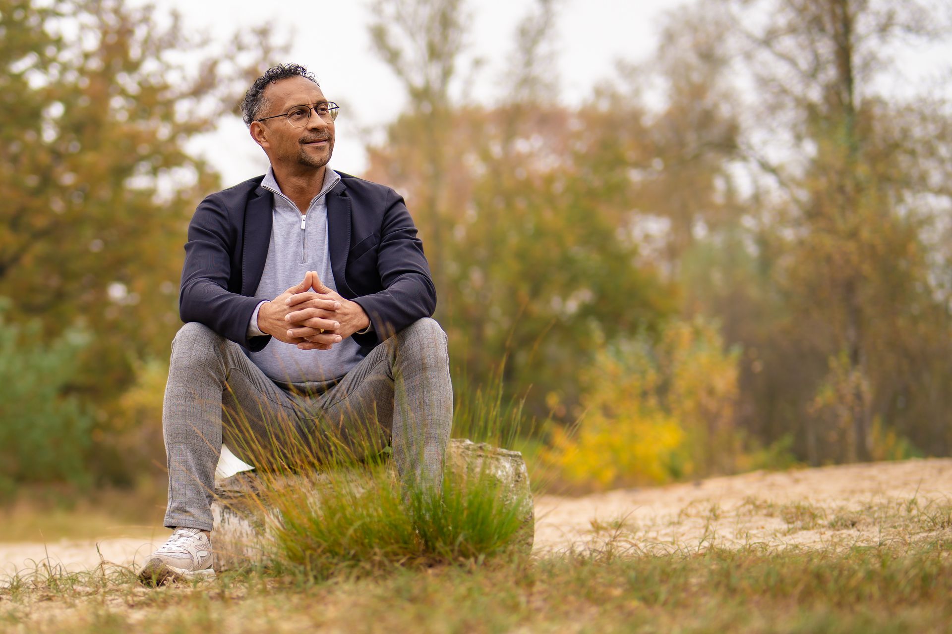 Reza de Groot zittend in het landschap van Nimmerdor